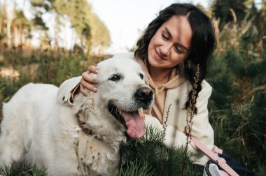 Golden Retriever köpeğini kucaklayan bir kız.