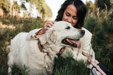 Golden Retriever köpeğini kucaklayan bir kız.