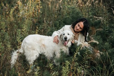 Golden Retriever köpeğini kucaklayan bir kız.