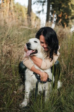 Golden Retriever köpeğini kucaklayan bir kız.