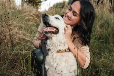 Golden Retriever köpeğini kucaklayan bir kız.