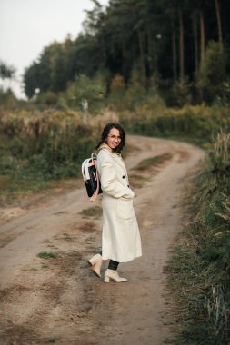 Orman yolunda sırt çantalı esmer kız.