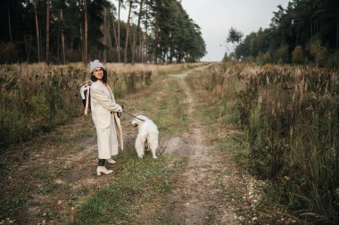 Golden Retriever köpeği olan kız orman yolunda yürüyor.