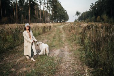 Golden Retriever köpeği olan kız orman yolunda yürüyor.