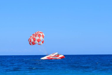 Kiris, Türkiye - 17 Haziran 2018: Powerboat turkuaz denizin Kiris, Türkiye'de paraşüt ile