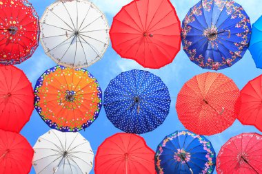 Mavi gökyüzüne karşı birçok renkli şemsiyeler