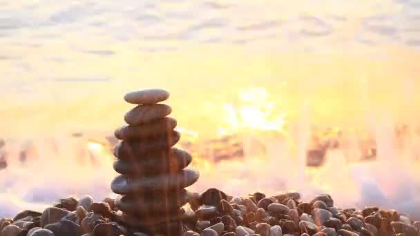 Pyramide de cailloux au lever du soleil sur la mer .