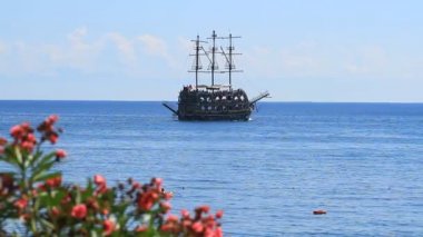 Kemer, Türkiye - 20 Haziran 2018: Zakkum çiçekleri ve Kemer, Türkiye'de Akdeniz denizlerde yelken bir korsan gemisi