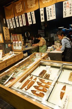 Nishiki pazarı, Kyoto 22 Ekim 2016: birçok yönden pişmiş balık çeşitleri satan bir balık satıcısı mağaza. Onun emri düzgünce sarılır gibi bir müşteri etrafında deponun içinde bakan.