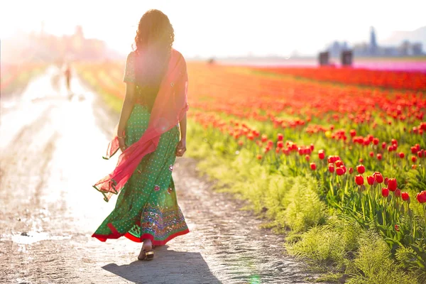 Belle femme indienne s'éloignant dans un champ de tulipes — Photo