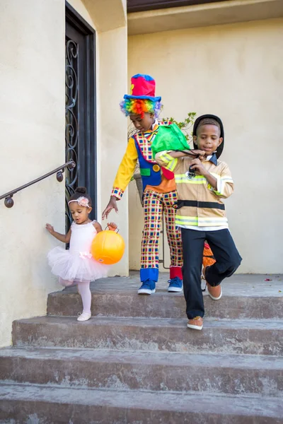 Enfants en costume à la maison pour tromper ou traiter Photo De Stock