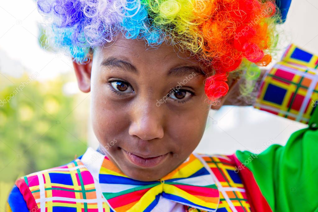 Cute preteen boy in clown costume looking at camera