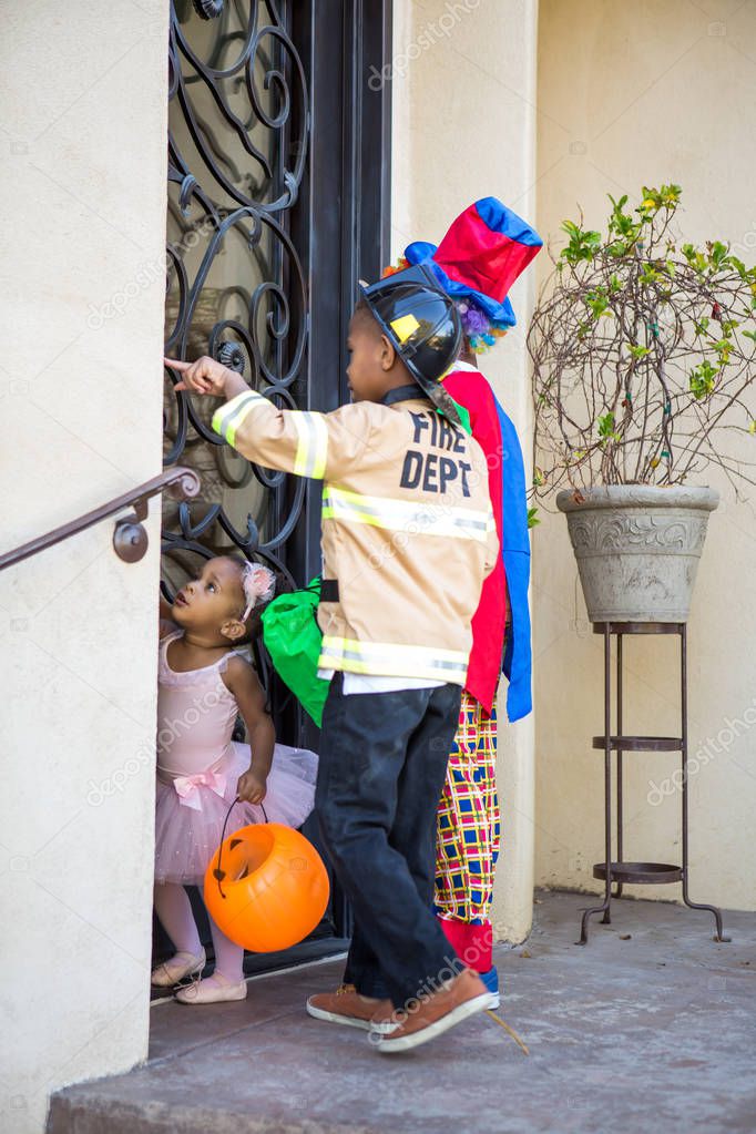 Children in costume at a home to trick or treat