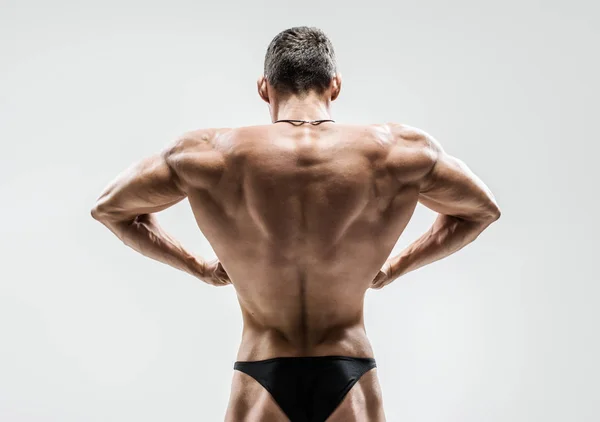 Fisiculturista Mostrar Músculos Mais Largos Das Costas Posar Fundo Cinza — Fotografia de Stock