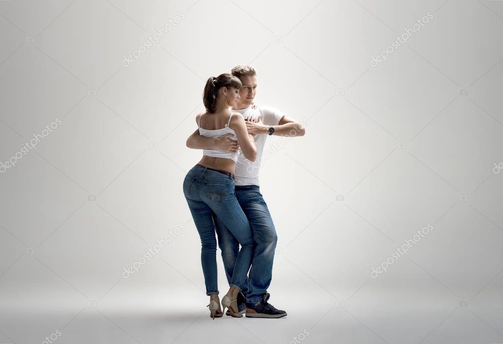 beauty couple dancing social danse ( kizomba or bachata or semba or taraxia) , on light-grey background