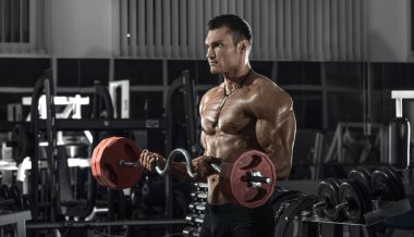 vücut geliştirmeci adam, koyu spor salonunda egzersiz halter ile gerçekleştirmek