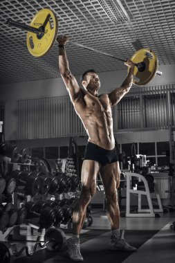 vücut geliştirmeci adam, koyu spor salonunda egzersiz ağırlık halter ile gerçekleştirmek