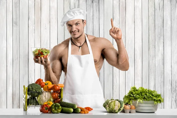 男性ボディービルダー白トークでキッチンにブランシュとクックの防護エプロン 調合野菜や果物 — ストック写真