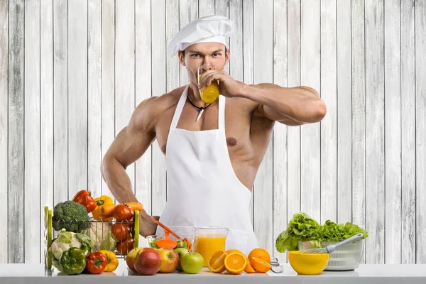 男性ボディービルダー クックはジュースと野菜のサラダを絞りたてキッチンで調理 — ストック写真