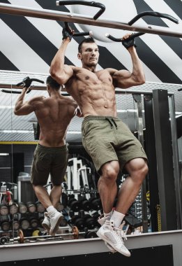 vücut geliştirmeci adam, egzersiz yapmak barfiks çekmek, spor salonunda, dikey fotoğraf yatay bar gerçekleştirmek