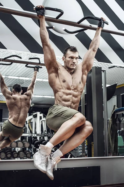 vücut geliştirmeci adam, egzersiz yapmak barfiks çekmek, spor salonunda, dikey fotoğraf yatay bar gerçekleştirmek