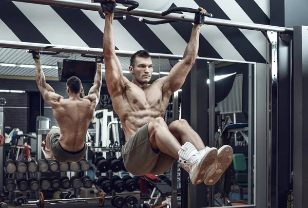 guy bodybuilder , perform exercise do chin-ups, horizontal bar in gym