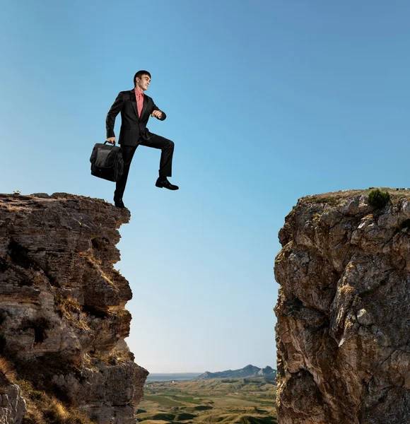 Hombre de negocios camina por un abismo — Foto de Stock