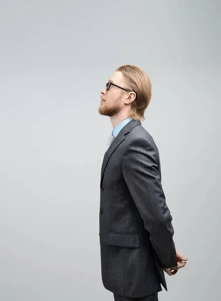 垂直の肖像画眼鏡の男ビジネスマンやオフィスワーカー スタンドサイドビュー グレーの背景に — ストック写真