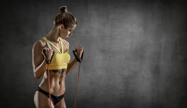 Retrato Joven Fitness Mujer Realiza Ejercicio Sobre Fondo Pared Gris — Foto de Stock