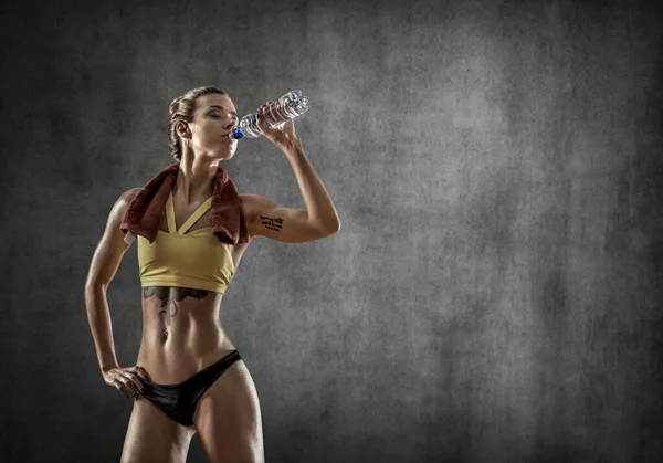 Jong Fitness Vrouw Drinken Van Fles Water Grijze Muur Achtergrond — Stockfoto