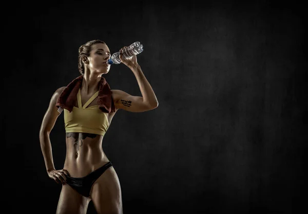 Genç Fitness Kadını Siyah Arka Planda Şişeden Içiyor — Stok fotoğraf