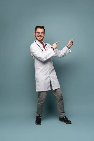 Ett porträtt av en läkare poserar mot grå bakgrund — Stockfoto