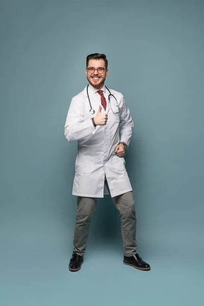 Um retrato de um médico posando contra fundo cinza — Fotografia de Stock