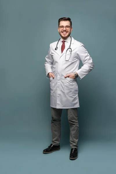 A portrait of a medical doctor posing against gray background — Stock Photo, Image