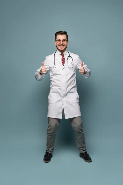 Um retrato de um médico posando contra fundo cinza — Fotografia de Stock