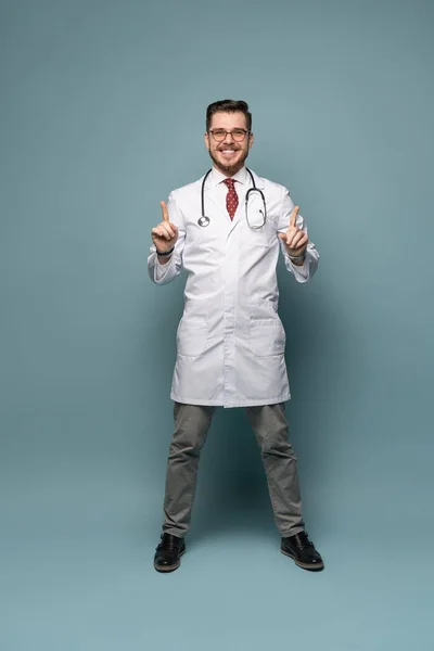 Een portret van een arts poserend tegen grijze achtergrond — Stockfoto