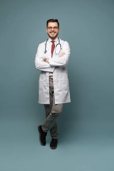 Um retrato de um médico posando contra fundo cinza — Fotografia de Stock