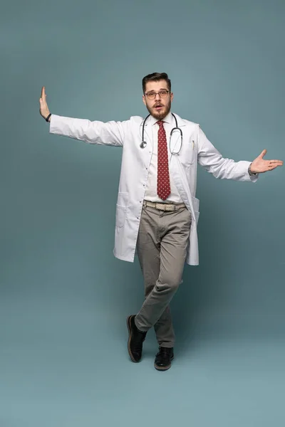 Um retrato de um médico posando contra fundo cinza — Fotografia de Stock