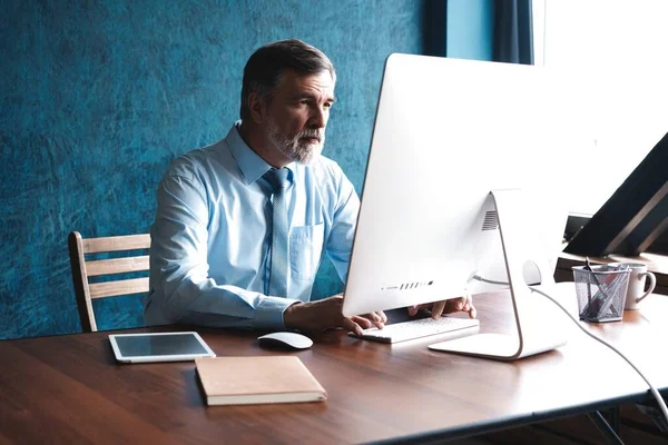 Volwassen zakenman werkt op de computer in Office — Stockfoto