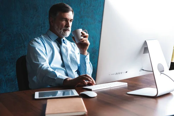Volwassen zakenman werkt op de computer in Office — Stockfoto