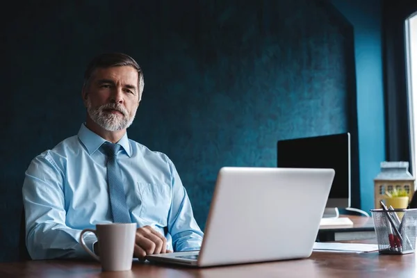 Senior man in kantoor werkt op laptop computer — Stockfoto