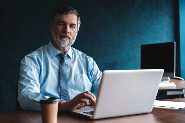 Senior man in kantoor werkt op laptop computer — Stockfoto