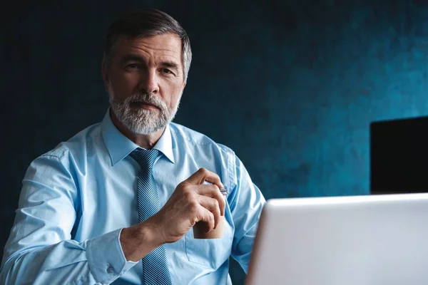 Senior man in kantoor werkt op laptop computer — Stockfoto