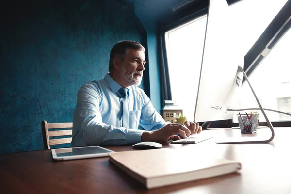 Volwassen zakenman werkt op de computer in Office — Stockfoto