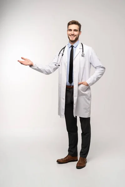 Docteur homme, professionnel de la santé présentant quelque chose d'isolé sur fond blanc. — Photo