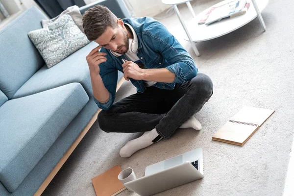 Guapo diseñador de hombre moderno que trabaja en el ordenador portátil en línea, el uso de Internet en casa — Foto de Stock