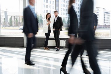 Beyaz yakalı işçiler mesai saatleri boyunca ofis koridorlarında yürüyorlar..