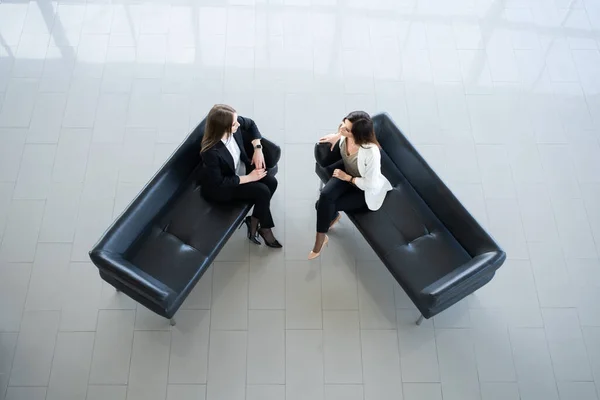 Ovanifrån av två affärskvinnor möte i receptionen av modernt kontor. — Stockfoto