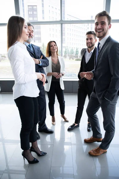 Grupp av upptagna affärsmän koncept. Affärsgrupp diskuterar arbete i kontorsbyggnad hall. — Stockfoto