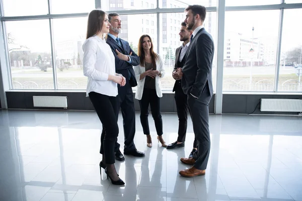 Gruppo di Busy Business People Concept. Business team discutere di lavoro in ufficio corridoio edificio. — Foto Stock